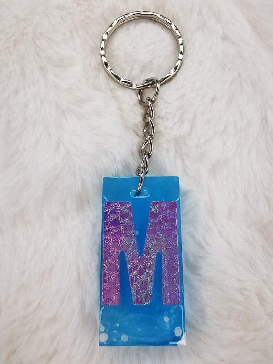 porte clé bleu avec M en holographique